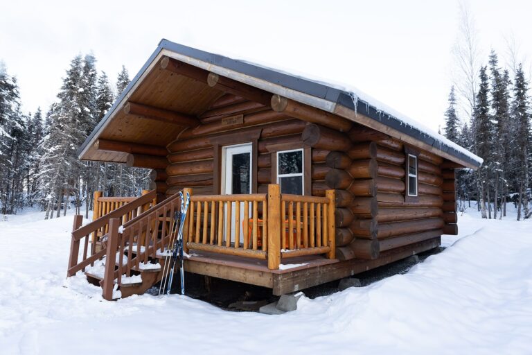 雪をかぶった丸太小屋の壁と窓