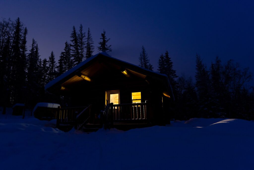 夜の雪原に立つ小屋