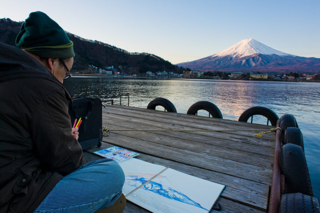 桟橋で絵を描く人。山を見に来た人は、たいていしばらく動かない