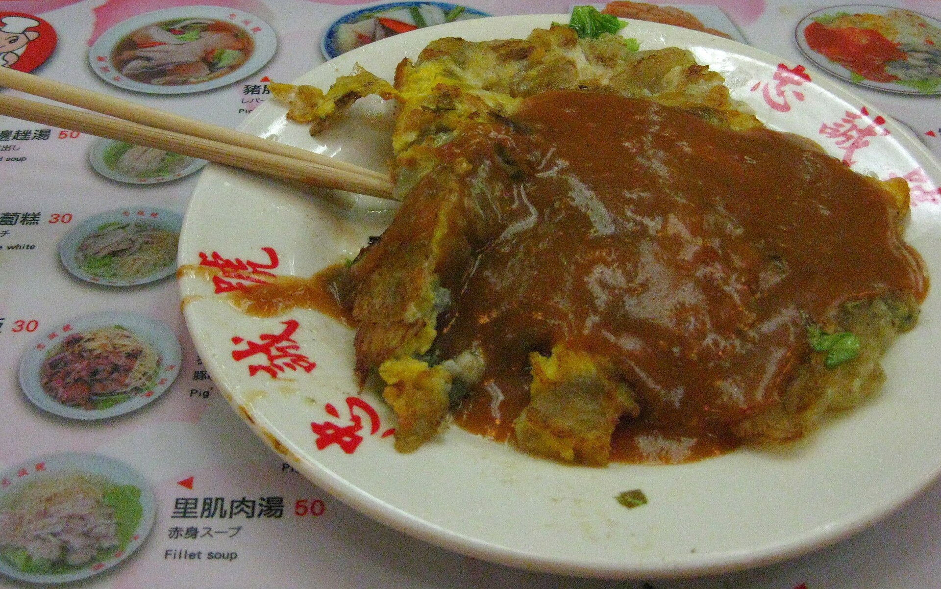 士林夜市の蚵仔煎。卓上の品書きの上に置かれた皿