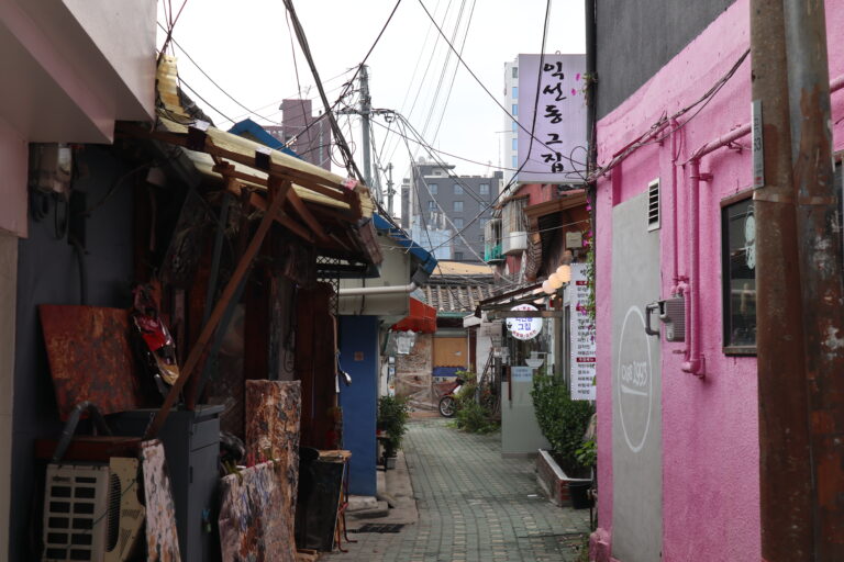ピンク色の外壁の店舗と路地