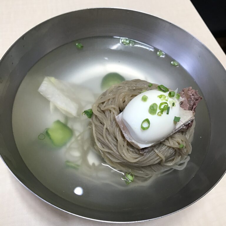 冷たいスープに入った灰色の細い麺