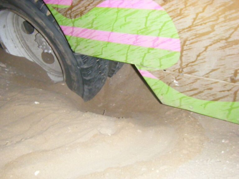 砂に埋もれた四輪駆動車のタイヤ