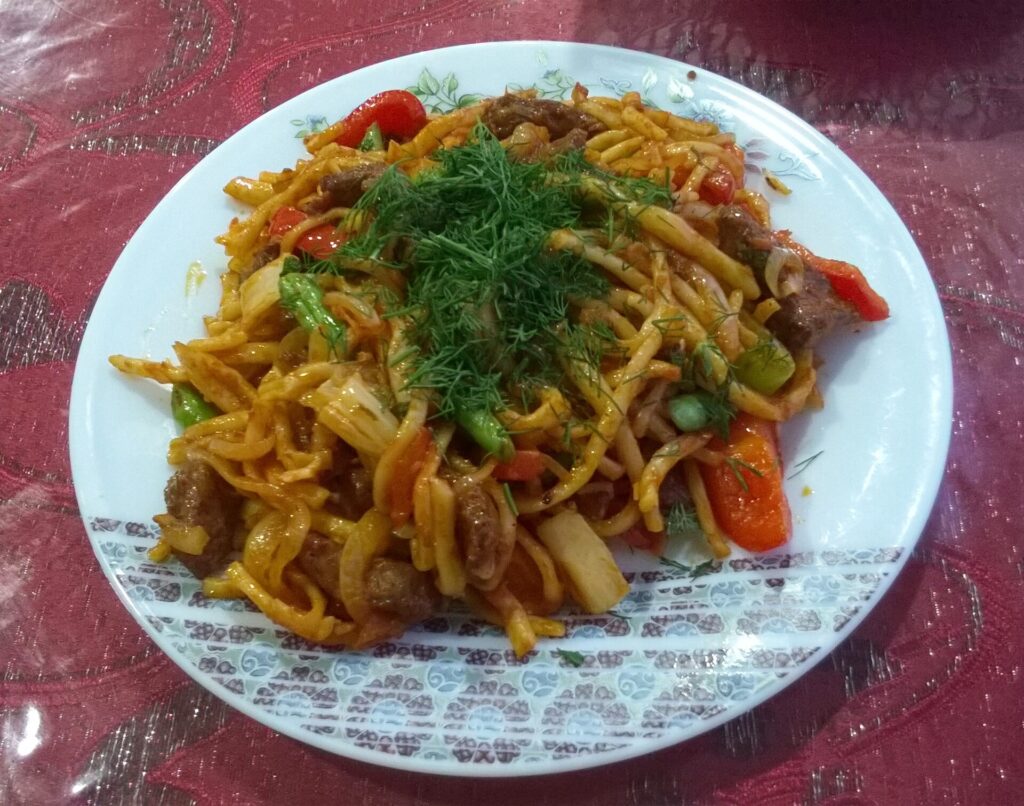 太い麺に野菜と肉の具をかけた料理