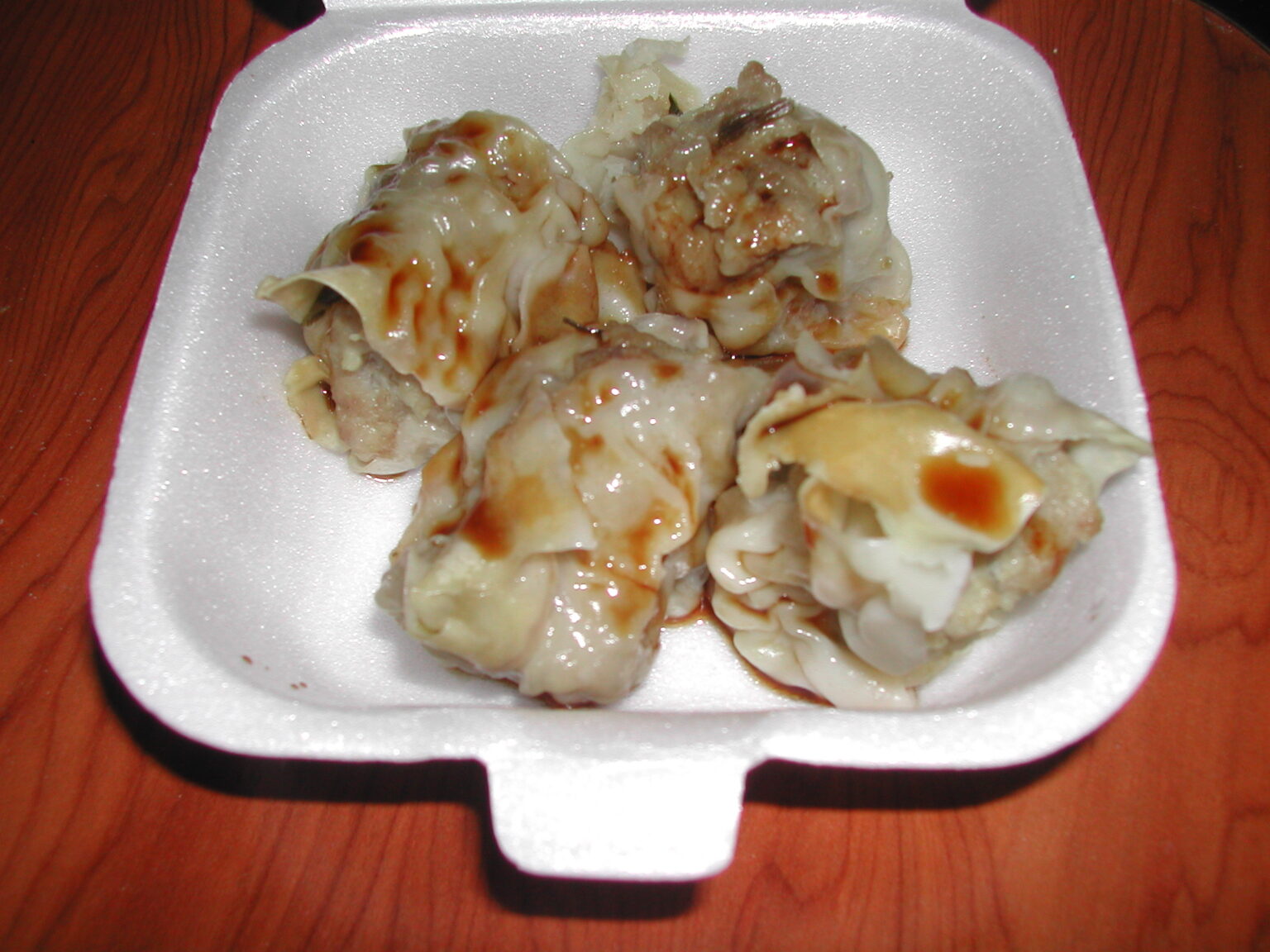 発泡トレーに入った、たれのかかったブション（蒸し餃子）