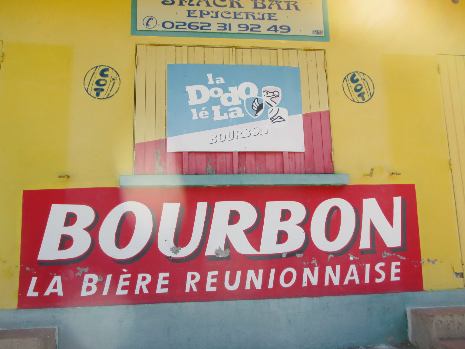 黄色い商店の壁に掲げられた「BOURBON LA BIÈRE RÉUNIONNAISE」の看板