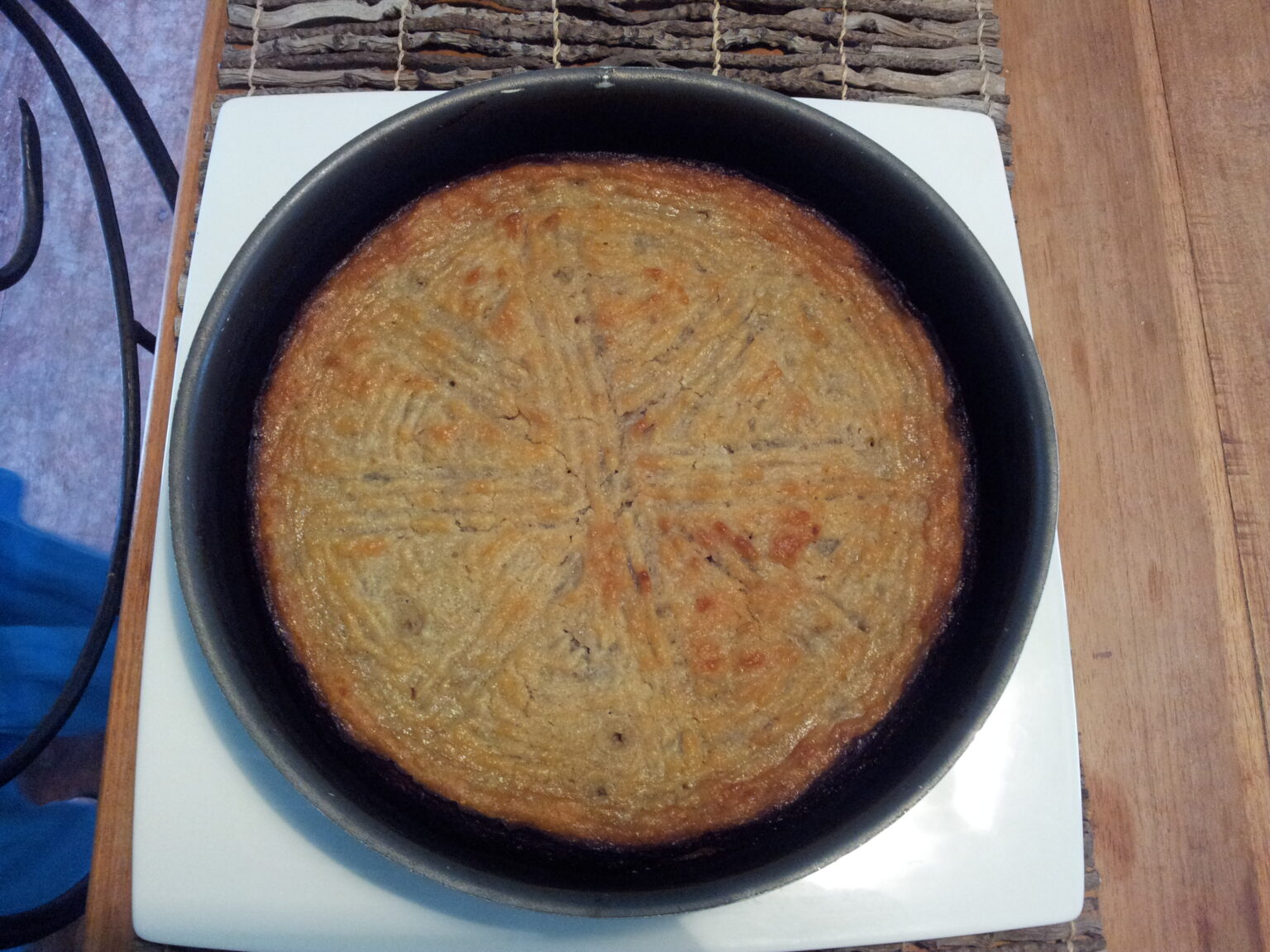 黒い丸皿に焼き上げたガトー・パタト（さつまいもの菓子）
