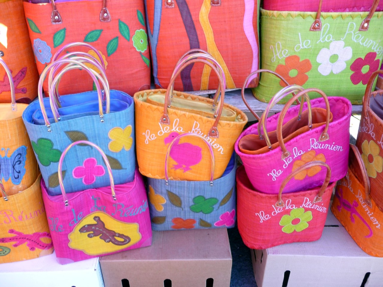 「La Réunion」と刺繍した色とりどりの買い物かごが並ぶ露店
