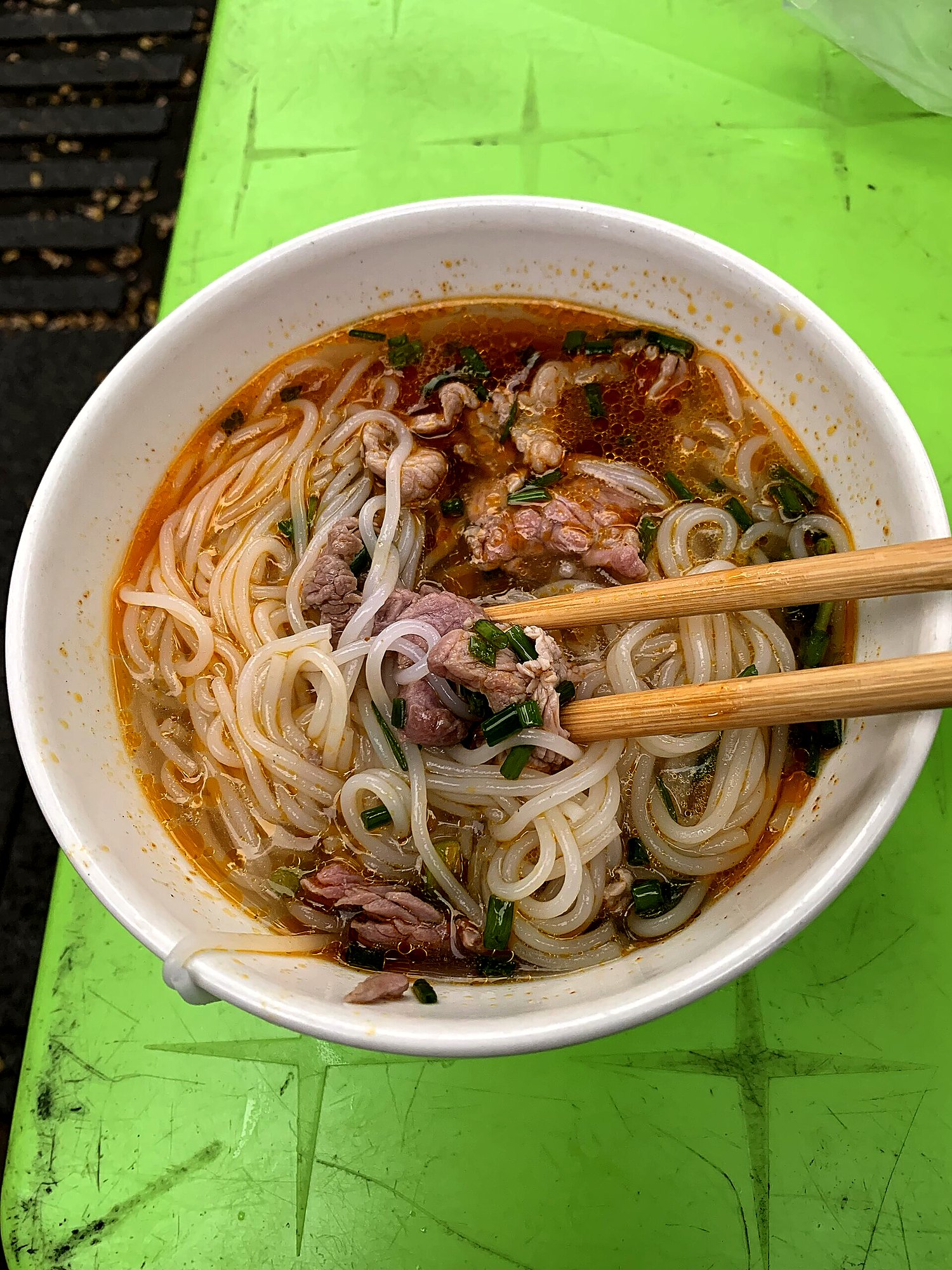 箸で丸い米麺を持ち上げているところ。麺の断面が丸いのが分かる