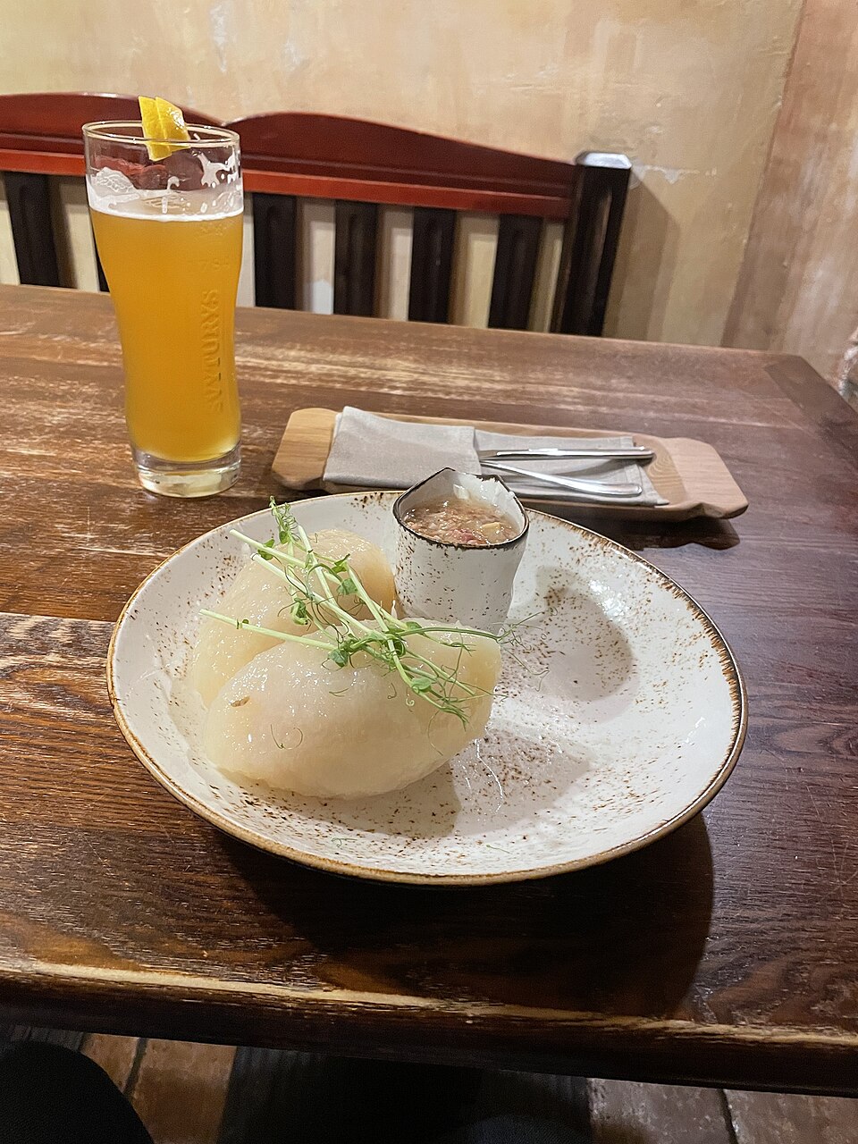 淡い色の皿に一つだけ盛られたツェペリナイと、奥のビールのグラス