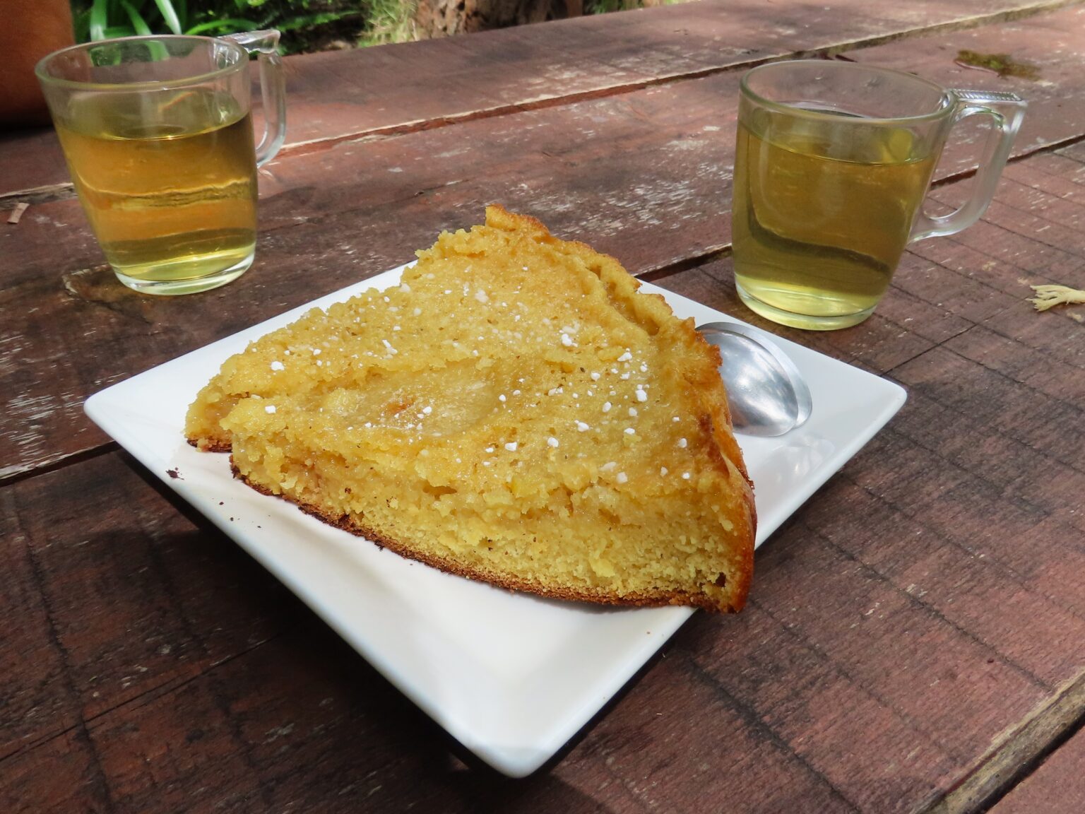 白い皿にのせた三角形のガトー・ティ・ソンと、2杯のお茶