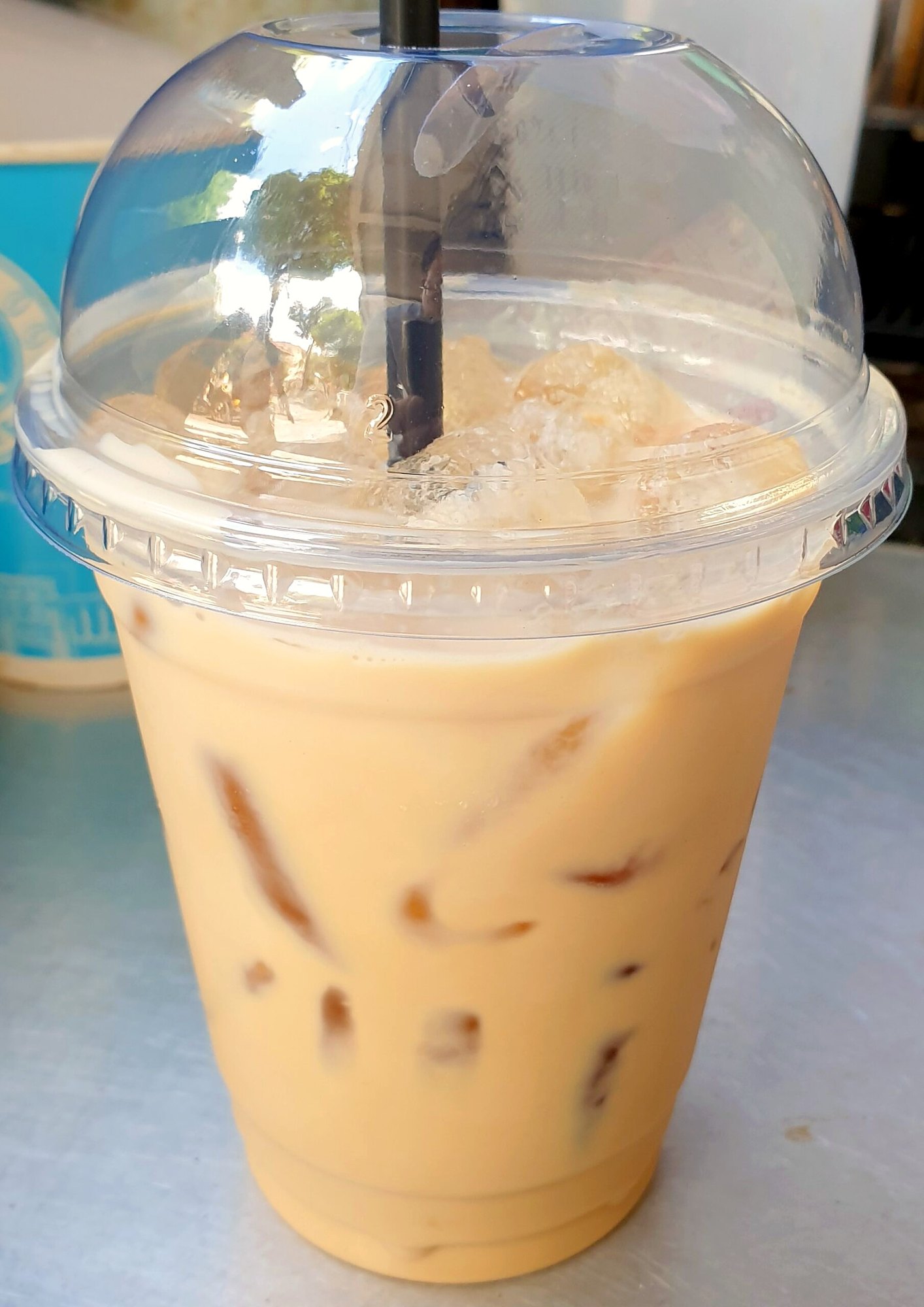 氷入りのbạc xỉu（ミルク多めのコーヒー）のプラカップ