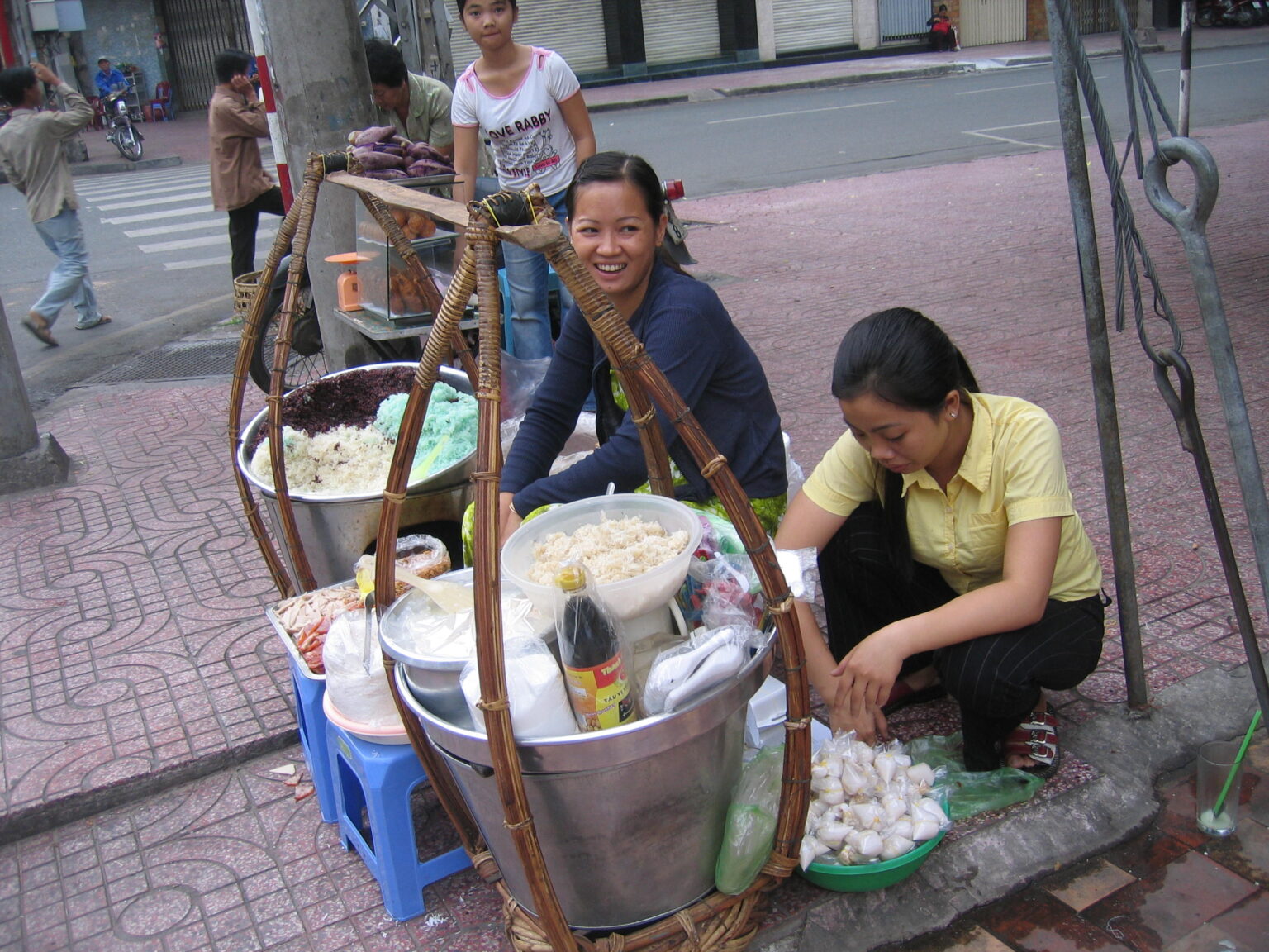 歩道に座り込んで天秤棒でxôi（おこわ）を売る女性（2005年）