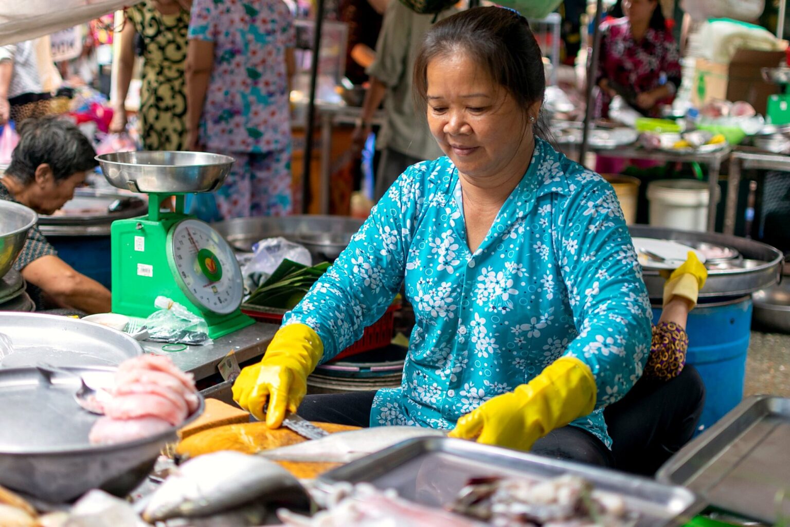 市場で魚をさばく女性