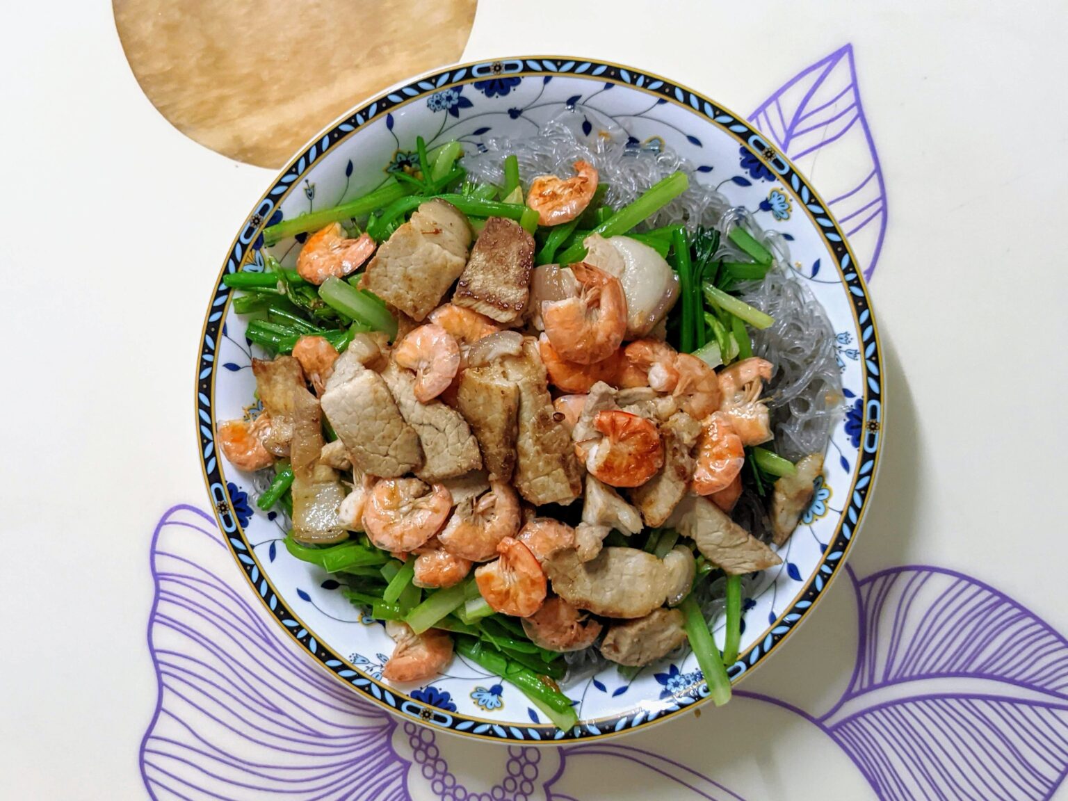 海老と豚肉、青菜をのせた汁なし米麺の皿