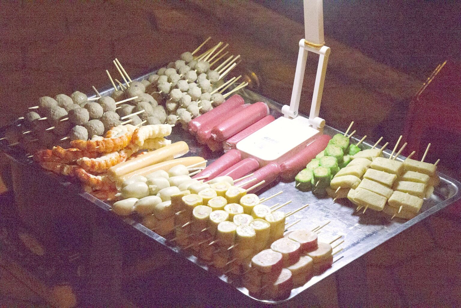串焼きが並ぶ屋台のトレー（ソーセージ・練り物）（2016年）