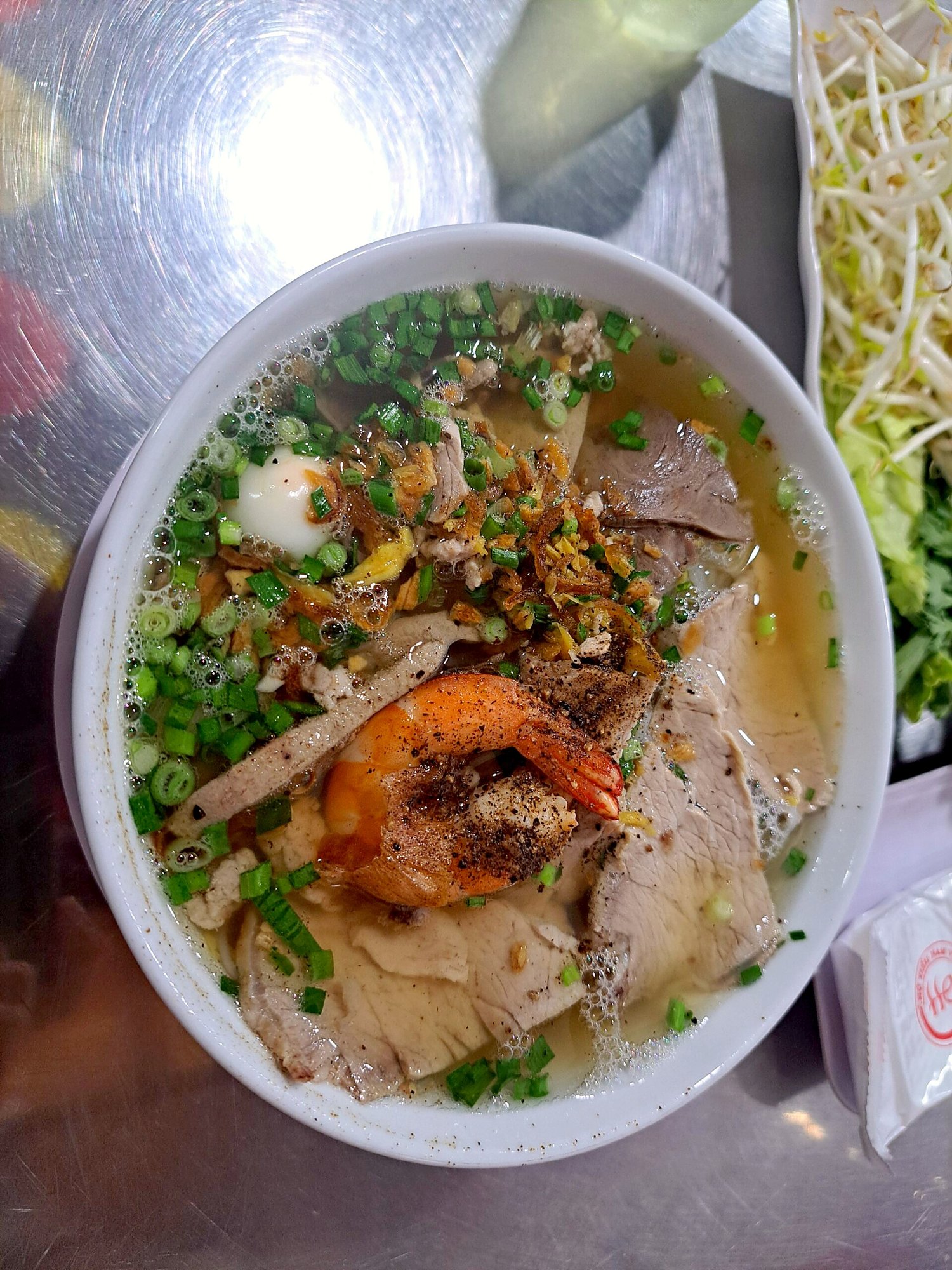 Bùi Viện通りの屋台で出されたhủ tiếuの丼。海老・豚肉・揚げ葱（2024年）