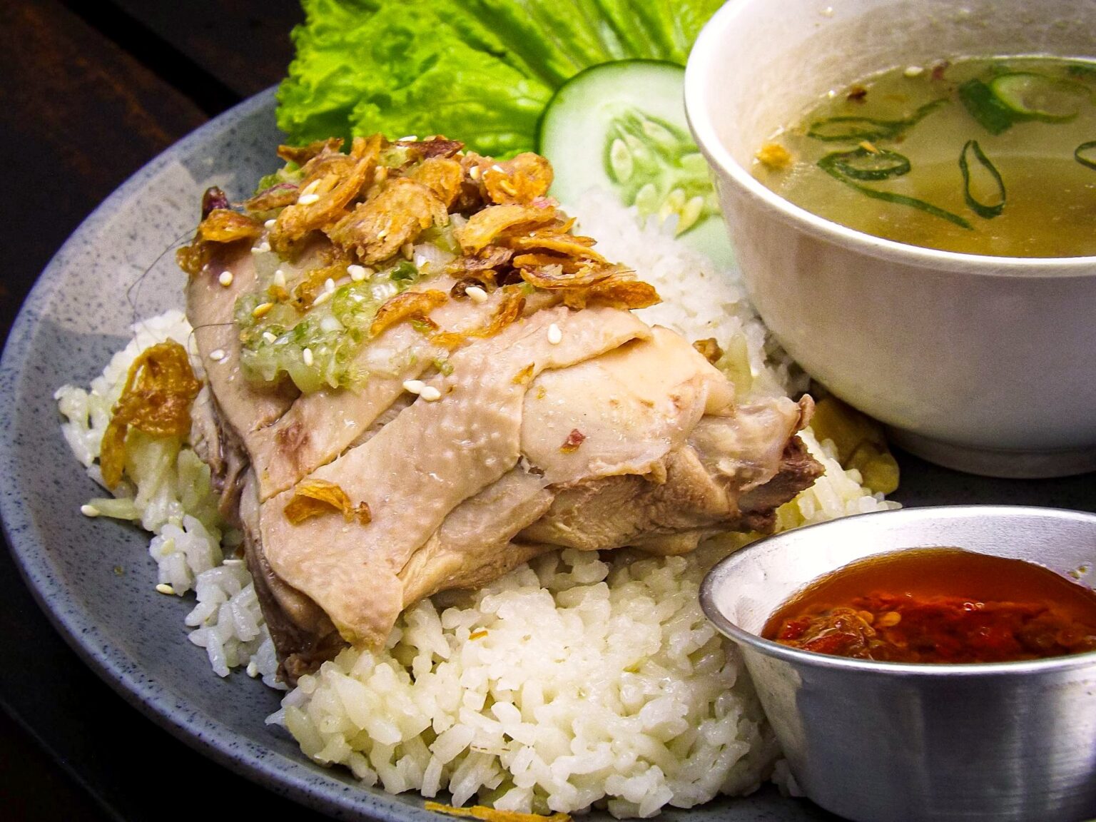 cơm gà Hải Nam。鶏出汁で炊いた米に茹で鶏、揚げ葱・スープ・チリソース