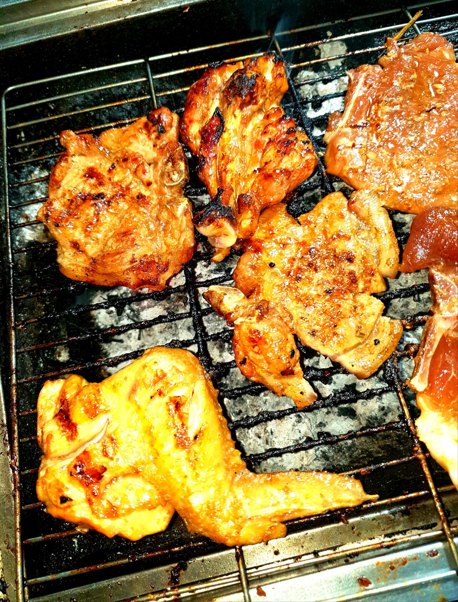 網の上で焦げ目がつく豚肉のアップ