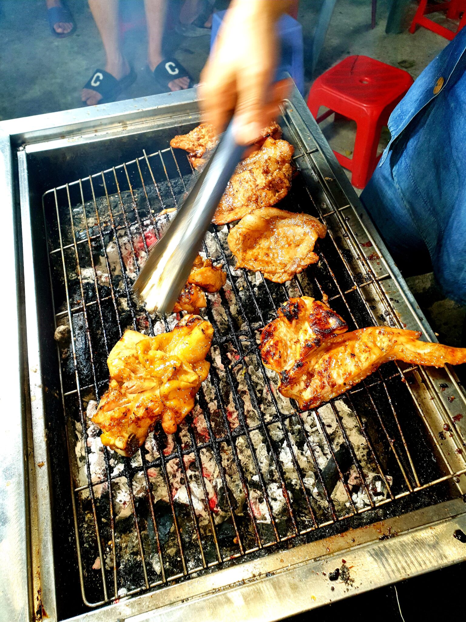 網の上で並んで焼かれる豚肉と手羽先