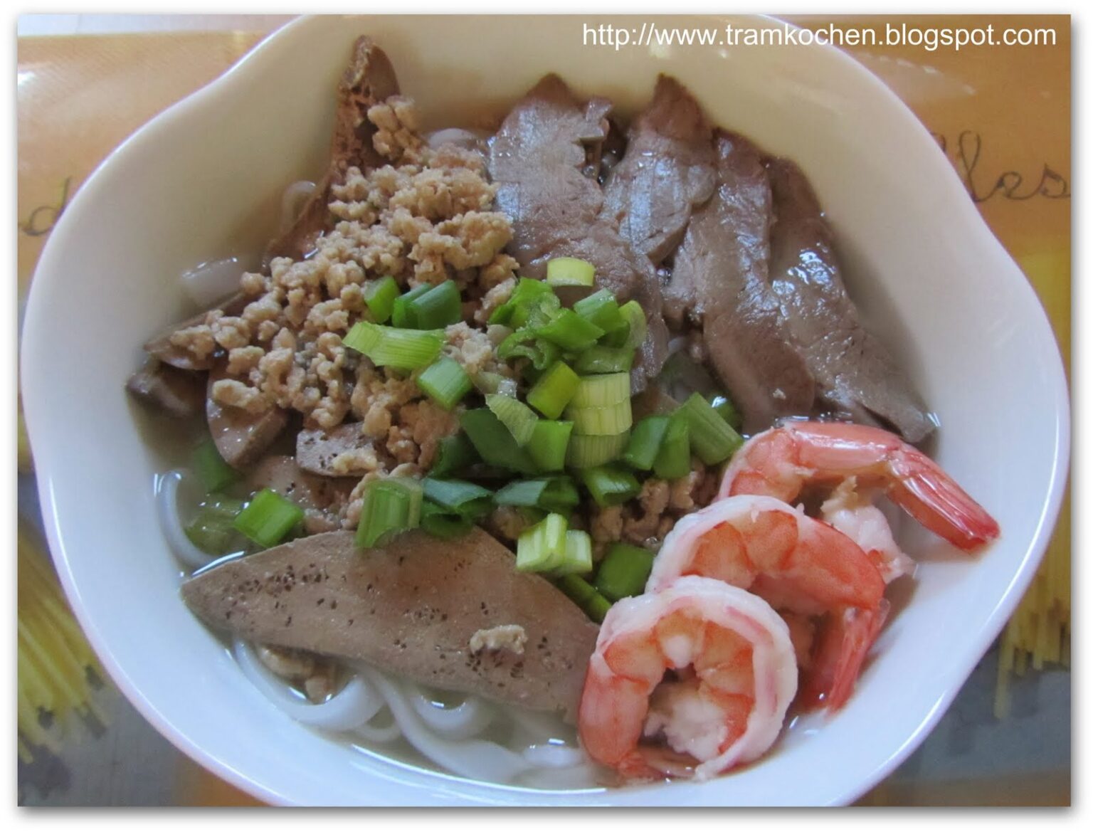 白い丼。細麺、海老3尾、豚肉スライス、レバー、ひき肉、刻みネギ・セロリ。上部に撮影者のブログURL