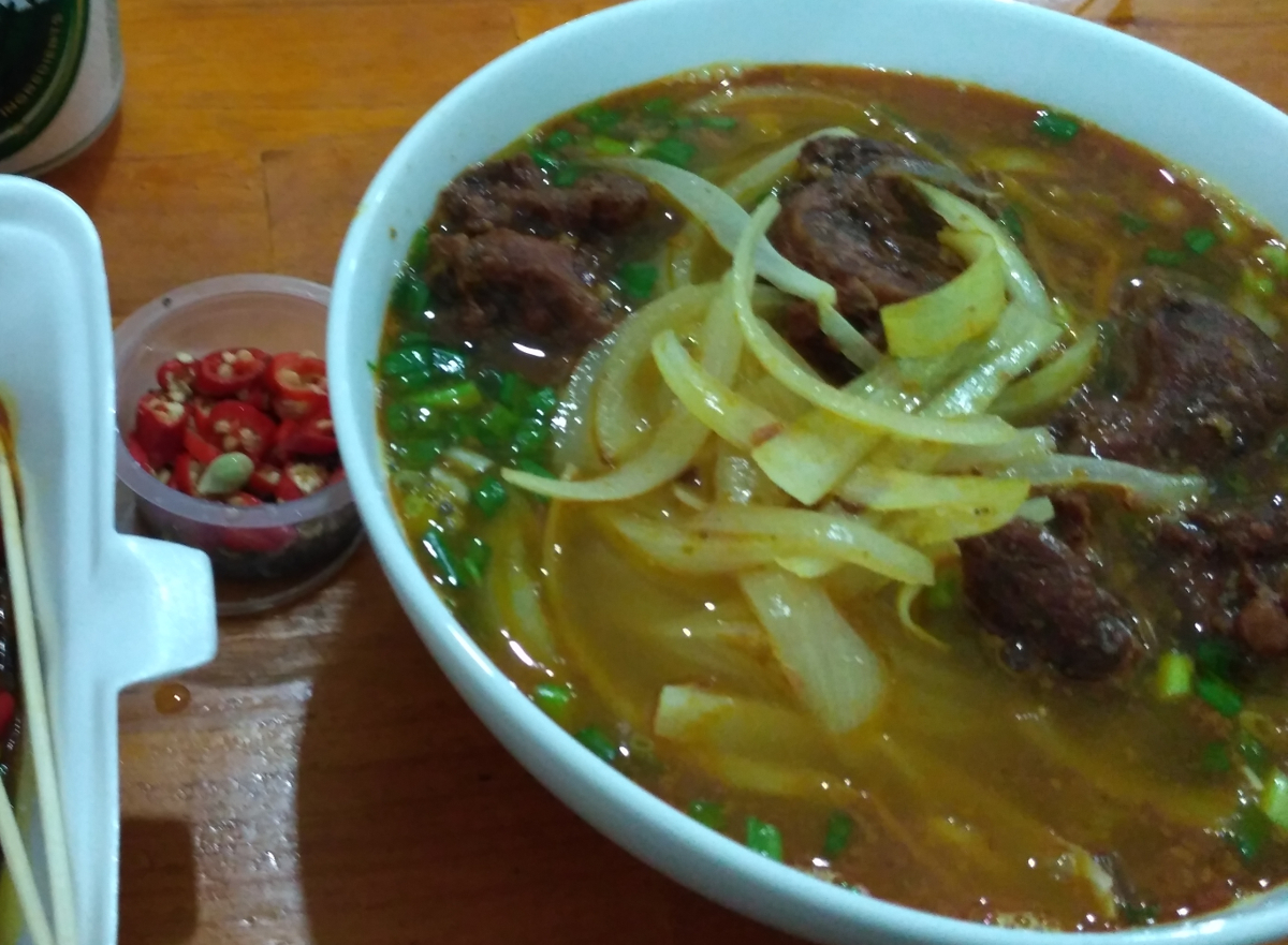 茶色い牛煮込みスープ（bò kho）のフーティウ、玉ねぎ。脇に唐辛子の小皿
