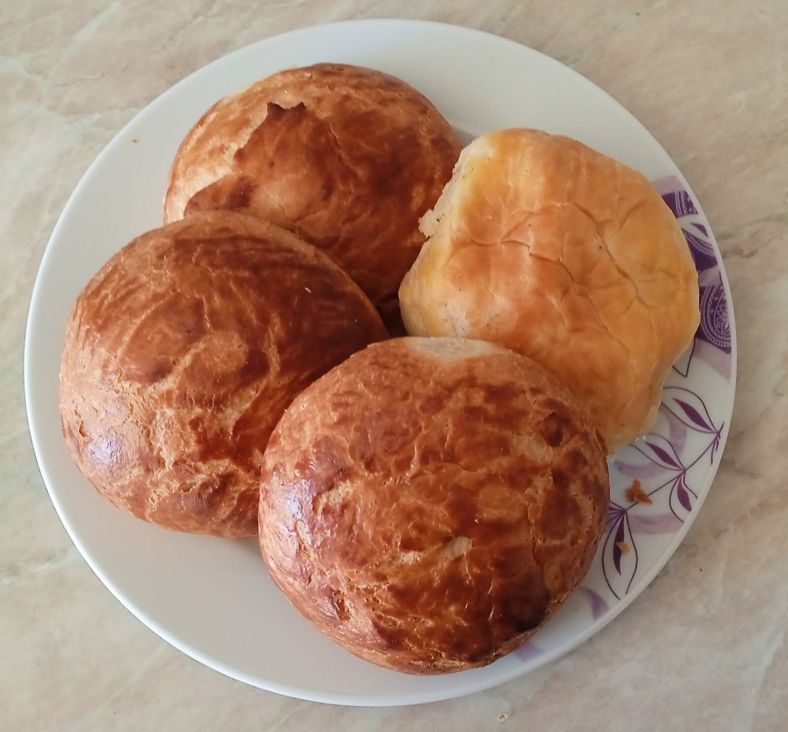 皿に盛った3個のプレーンなポアチャ（照りのある焼き色の丸いパン）