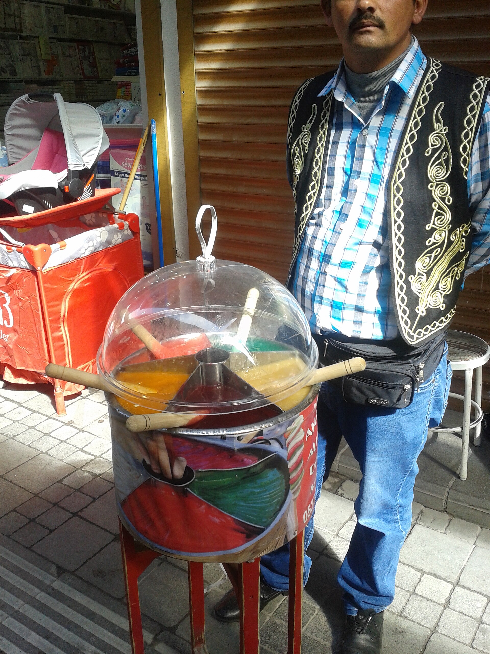 蓋付きの丸い缶に色とりどりの練り飴を入れた屋台と売り手