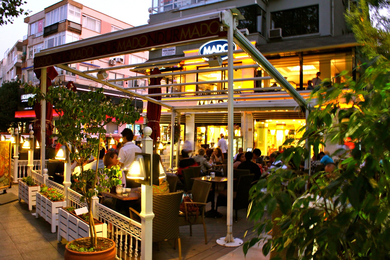 夕方に灯りのともる Mado の店先とテラス席