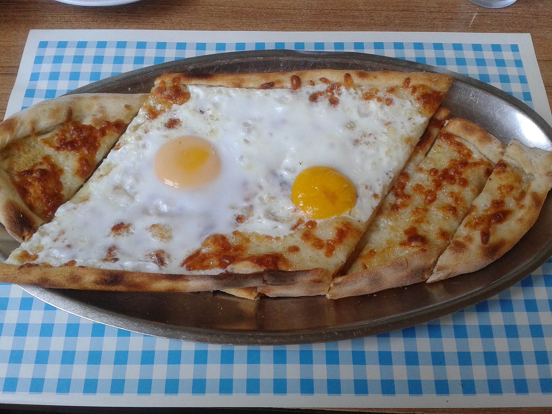 チーズと目玉焼き2つをのせた舟形のピデ