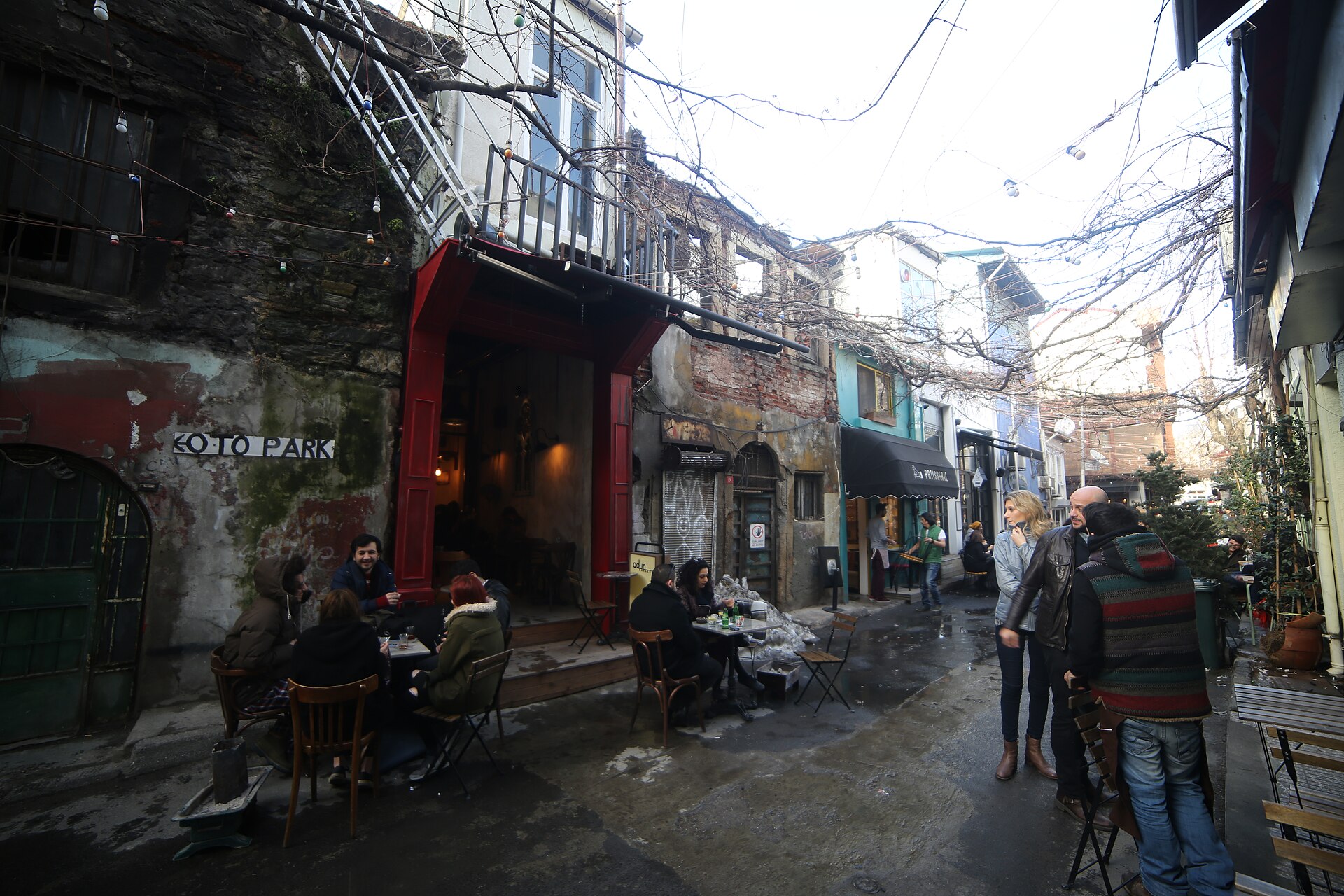 カラキョイの路地のカフェ、赤い日よけの店先と外に並ぶテーブル席