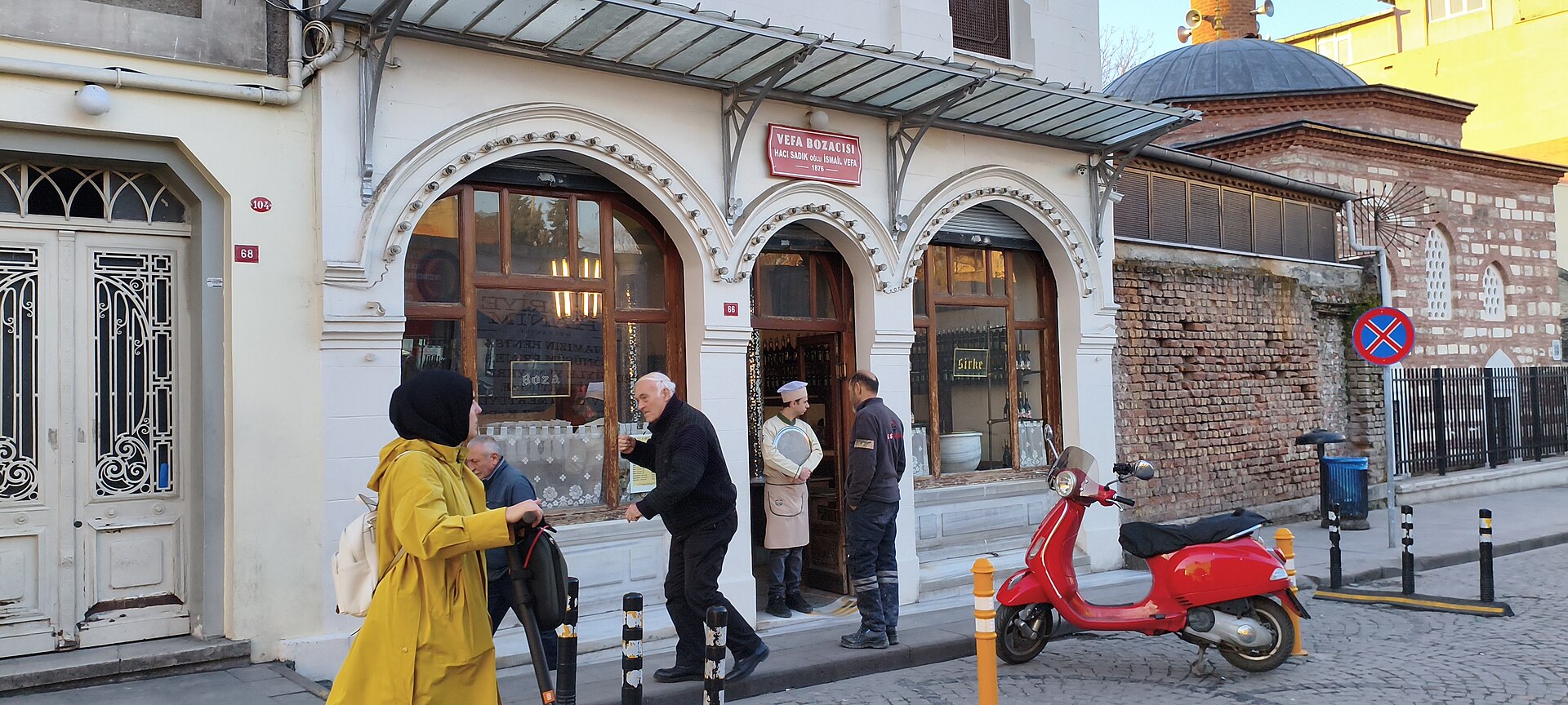 ヴェファの通りに面した Vefa Bozacısı の店構え、アーチ窓の古い建物と前を歩く人
