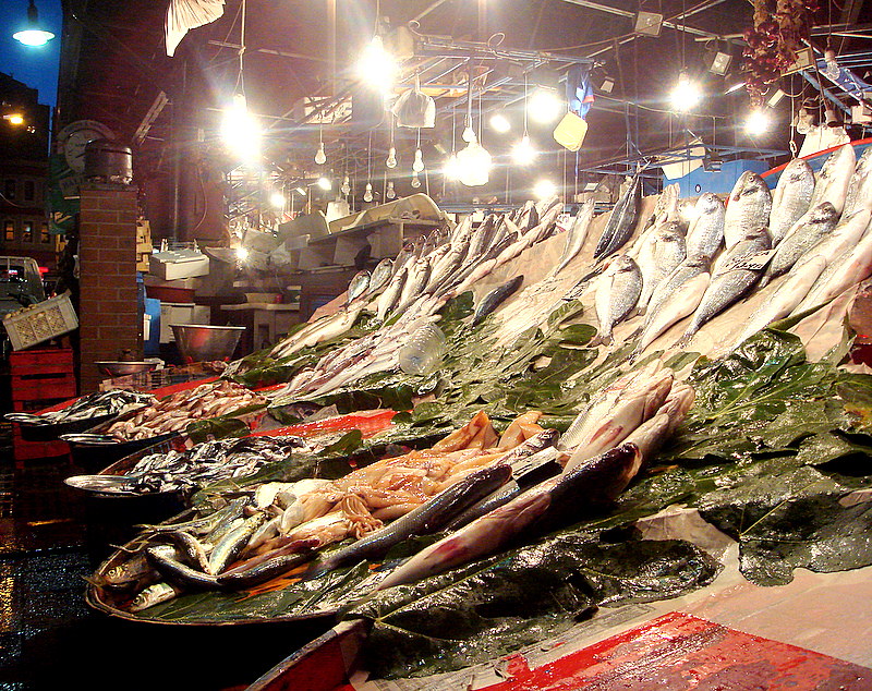 電球に照らされた魚屋の台に並ぶ大きな魚