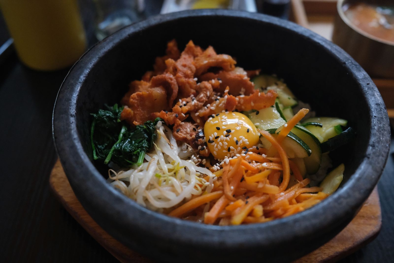 卵黄と野菜を盛った、石の器のビビンバ。