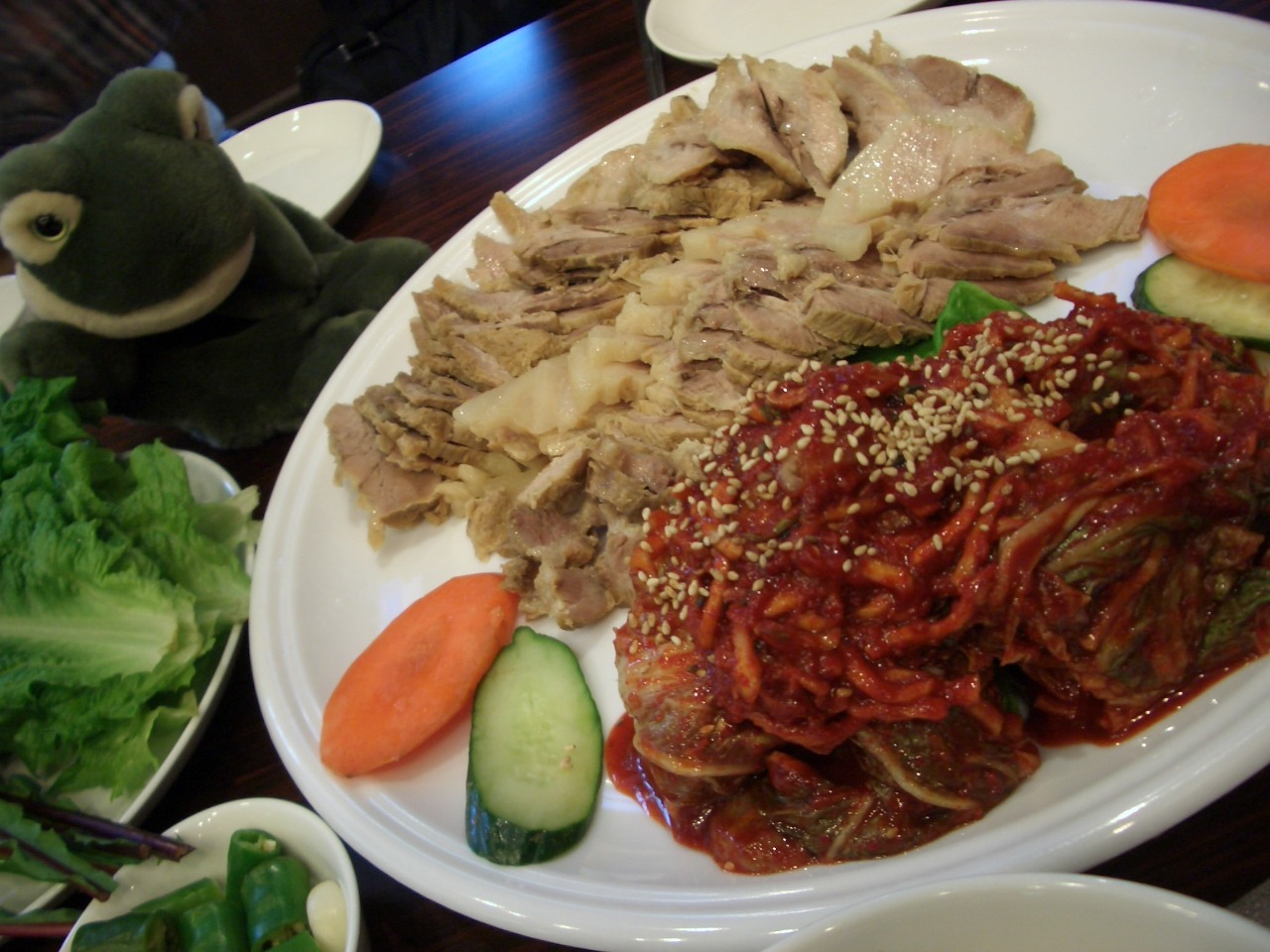 豚肉と、包んで食べる葉やキムチを盛った一皿。