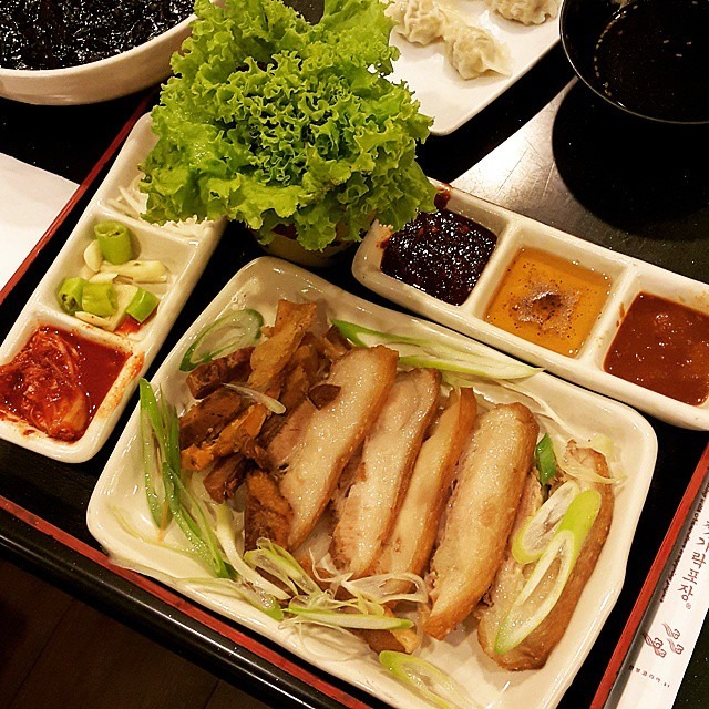 ゆで豚に葉と薬味を添えたポッサムの食卓。