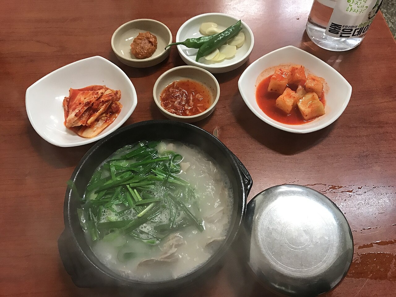 ニラと汁を合わせるテジクッパの食卓。