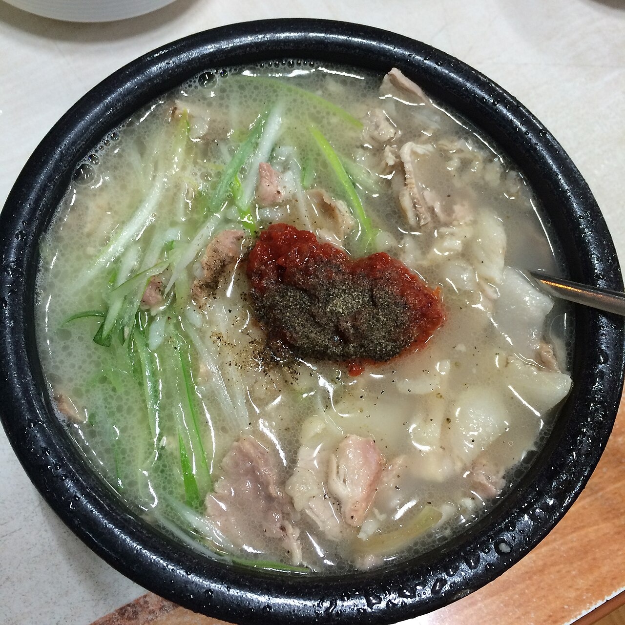 白い汁に赤い薬味を置いた一杯。