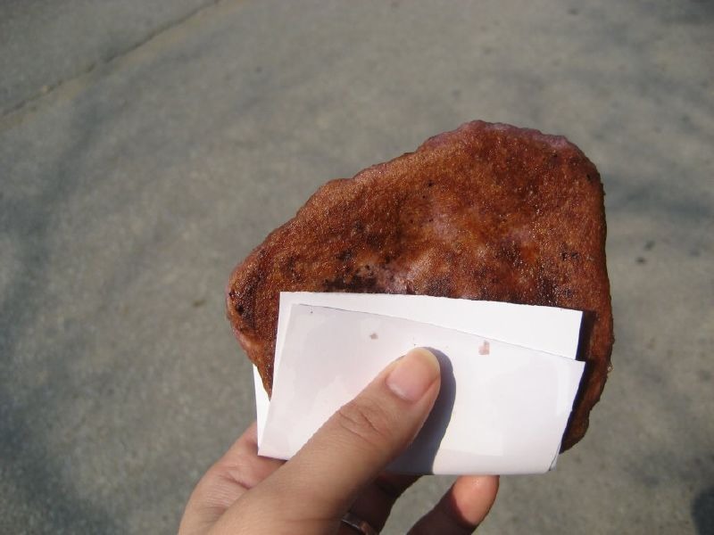 紙に挟んで渡される、食べ歩きのホットク。