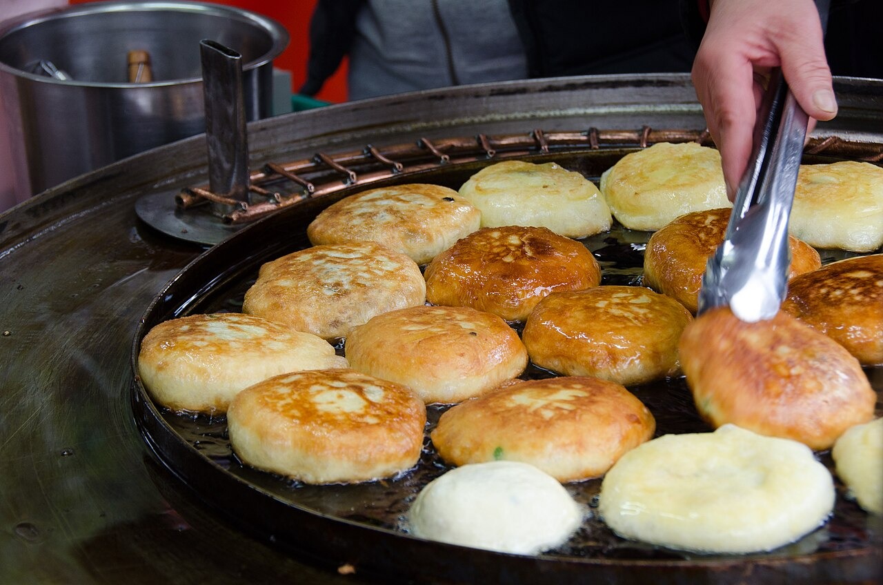 鉄板でいくつものホットクを同時に焼く。
