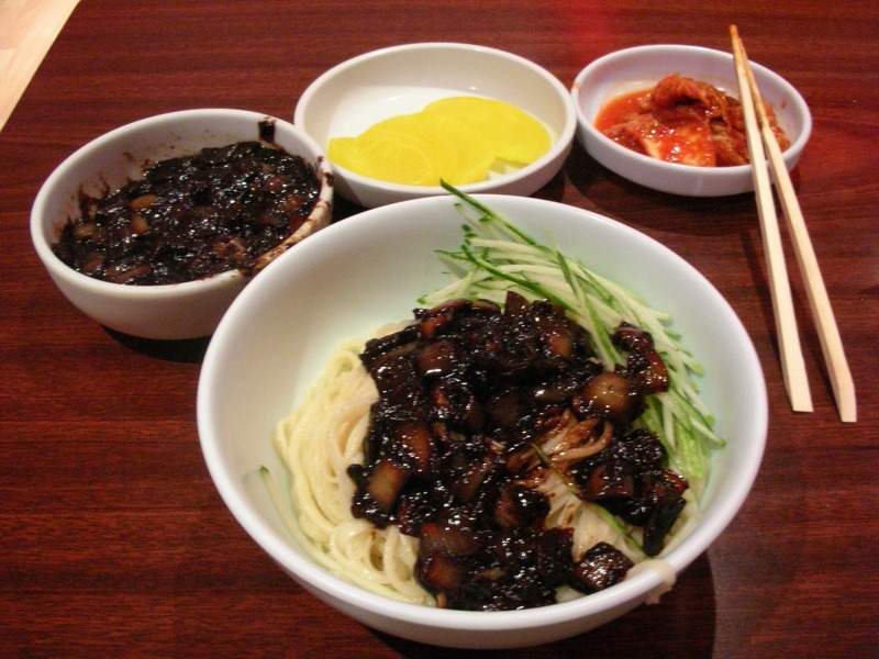 麺と黒いたれを別々に用意し、たくあんを添えた食卓。