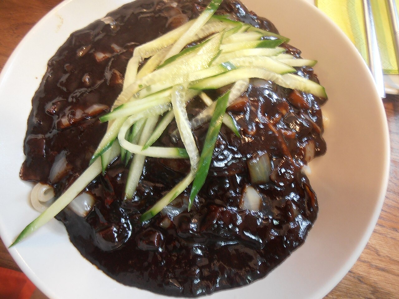 細切りきゅうりをのせた、黒いたれの麺。