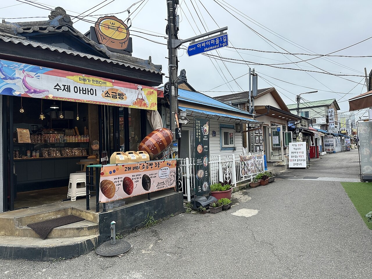 スンデやイカの料理を掲げるアバイ村の食堂の看板。