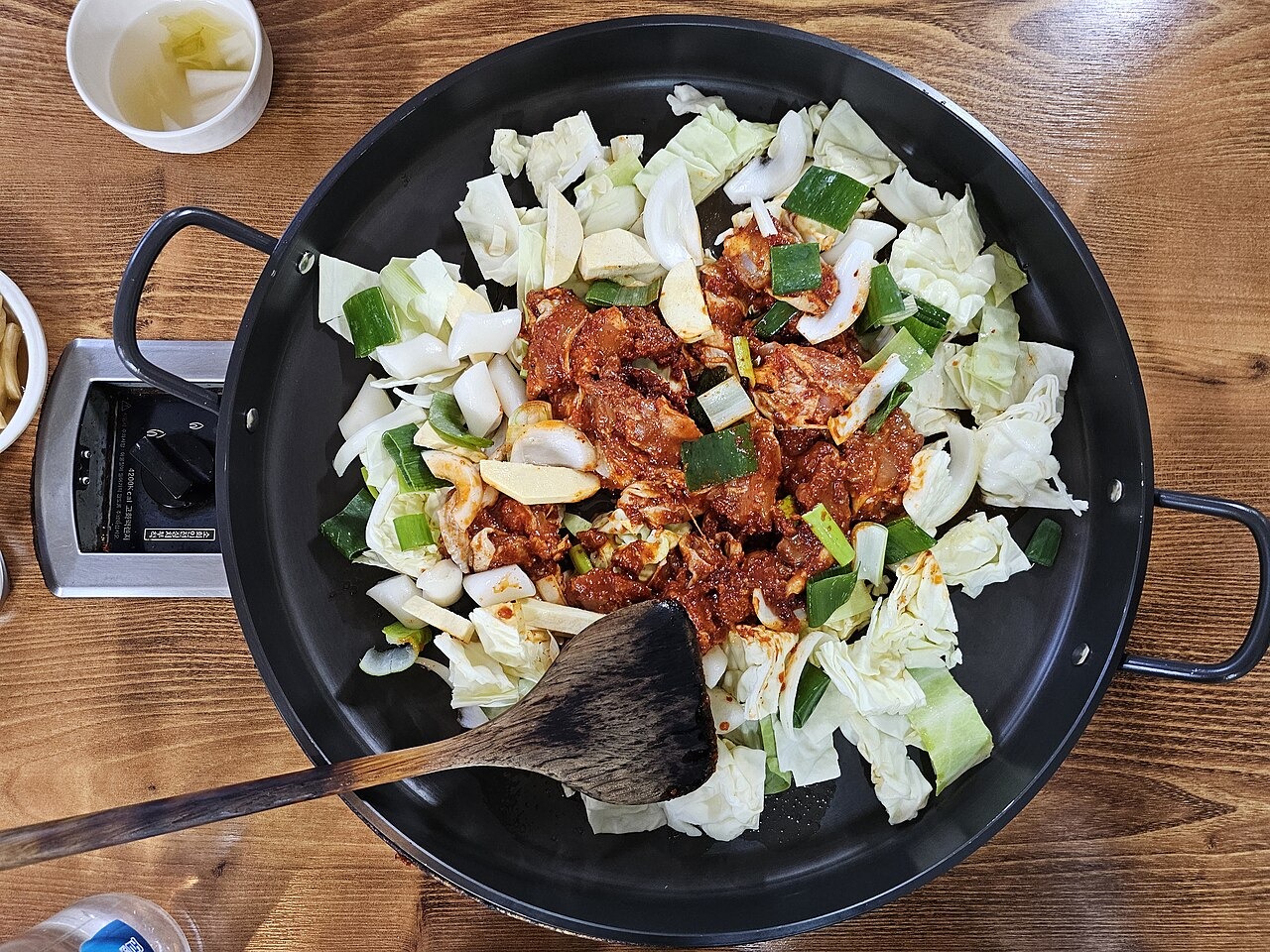 鉄板に入れた調理前の味付け鶏と野菜。
