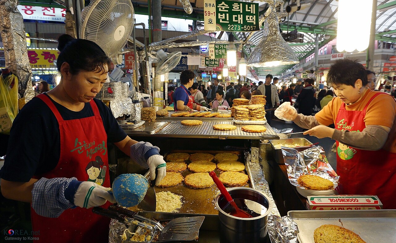 広蔵市場で緑豆の生地を鉄板で焼く仕事。
