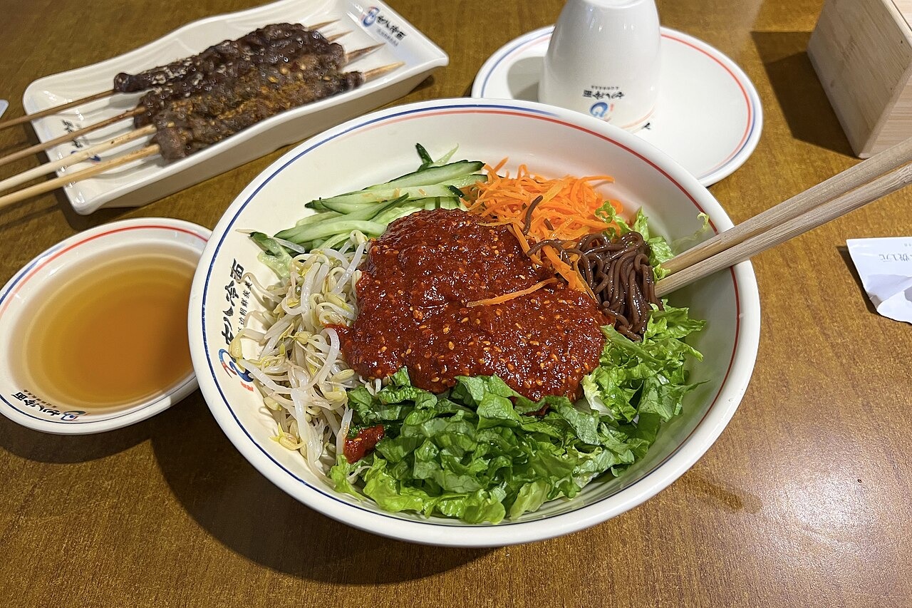 北京の食堂で出された、赤いたれを混ぜる冷麺。