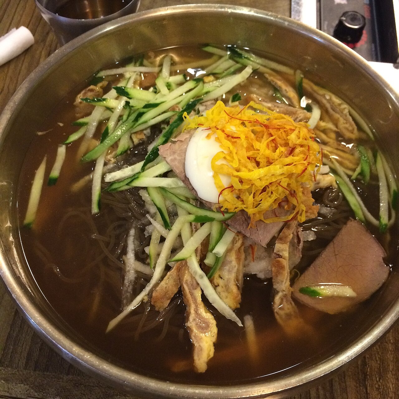 牛肉のチヂミなどを細く切ってのせる、晋州の冷麺。
