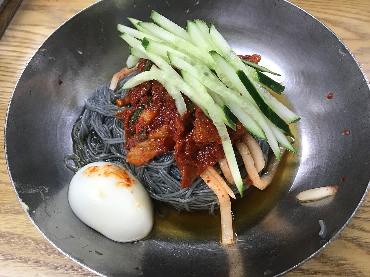 卵ときゅうりを添えた、色の濃い麺の一杯。