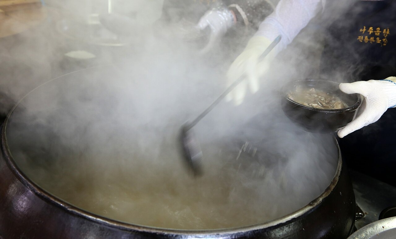 大釜の汁を器へ注ぐトリョムの仕事。