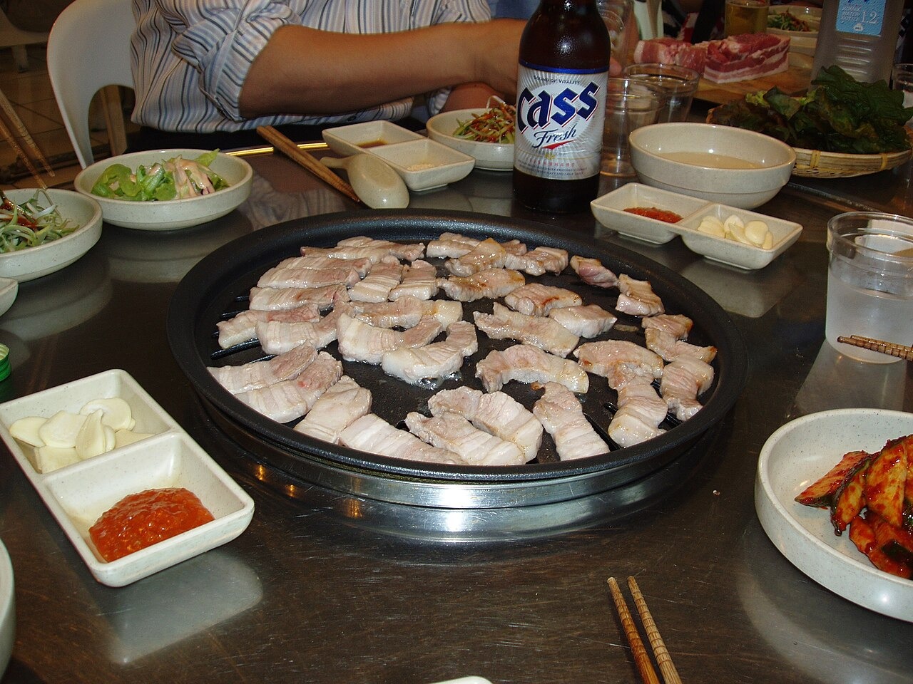 卓上で肉を焼きながら食べるサムギョプサル。